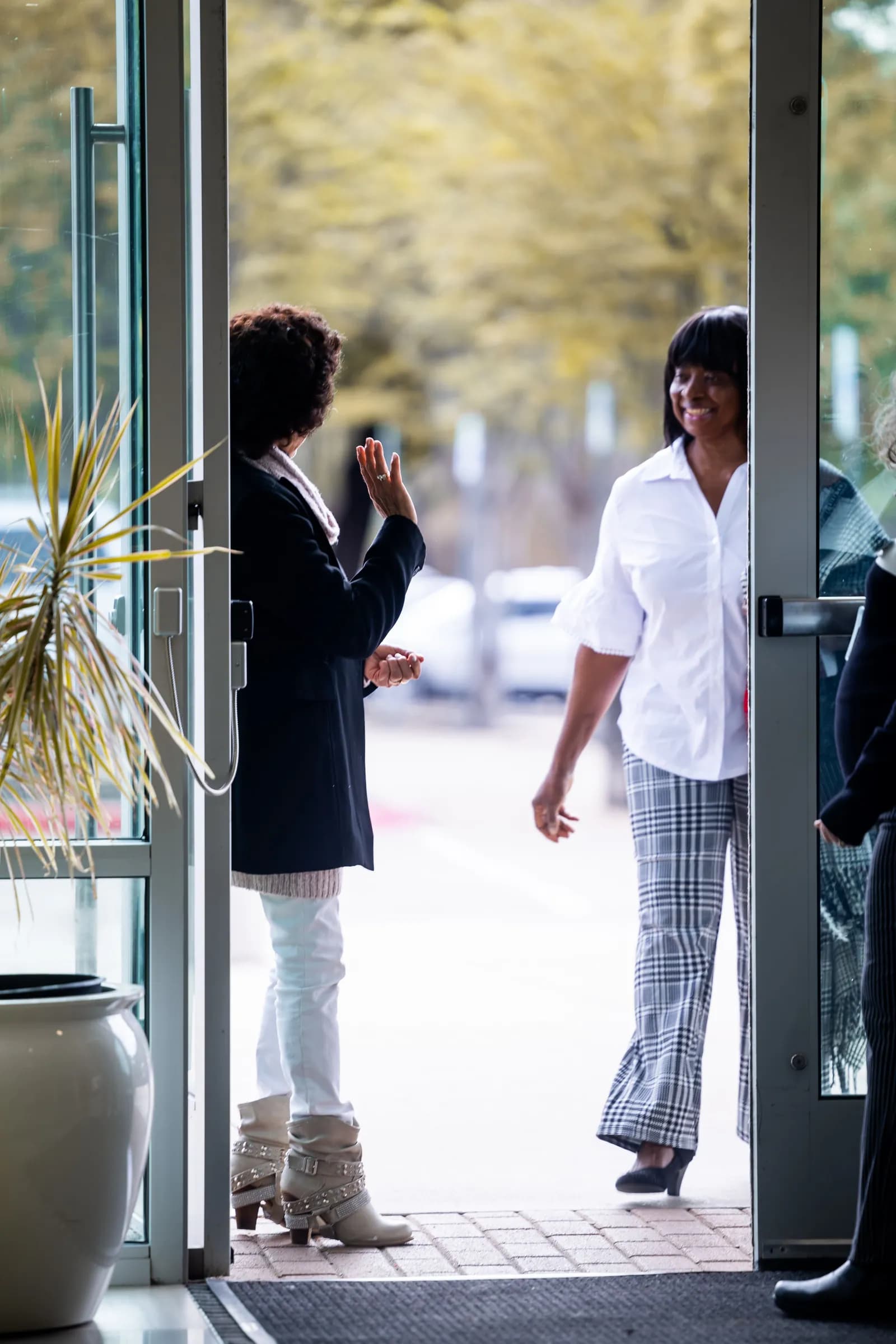 A visitor being greeted at an open doorway.